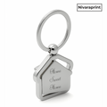 Silver house-shaped keychain with 'Home Sweet Home' engraving on a white background, featuring the brand 'Nivaraprint'.