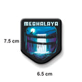 Fridge magnet with a design of a waterfall and 'MEGHALAYA' text on a metallic surface.