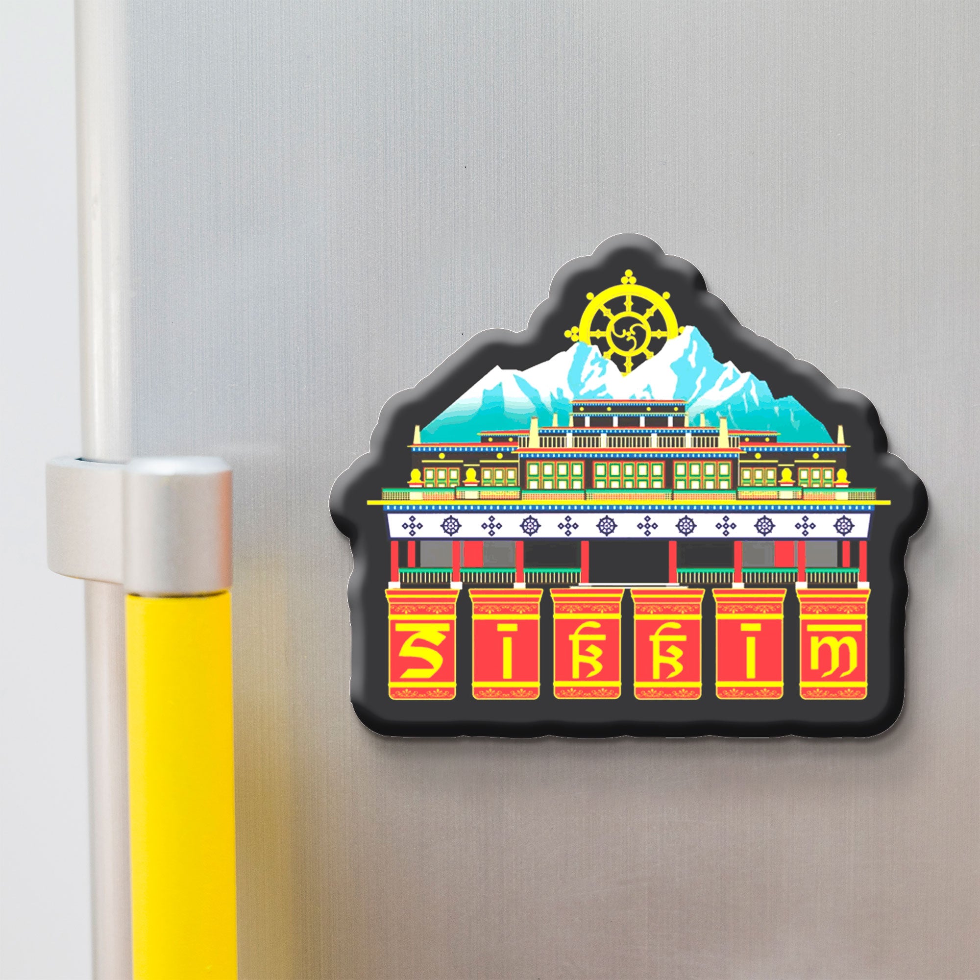 Decorative skkim magnet with a colorful design of a building and a mountain on a refrigerator.