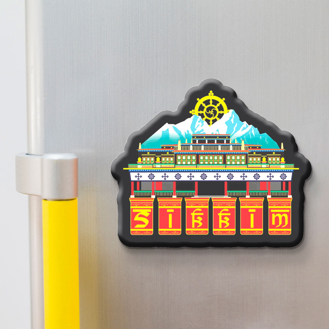 Decorative skkim magnet with a colorful design of a building and a mountain on a refrigerator.