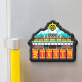 Decorative skkim magnet with a colorful design of a building and a mountain on a refrigerator.
